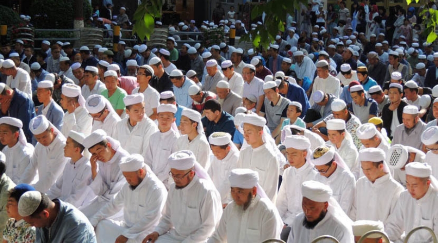 Muslims kneel down and pray to celebrate Eid al-Fitr at a mosque in Beijing