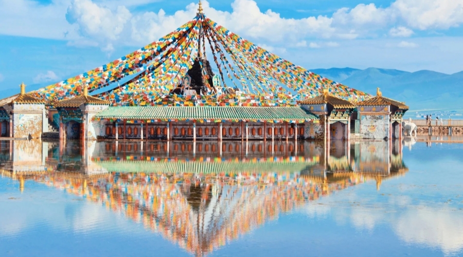 Colorful prayer flags reflect on the tranquil waters of Qinghai Lake near Xining
